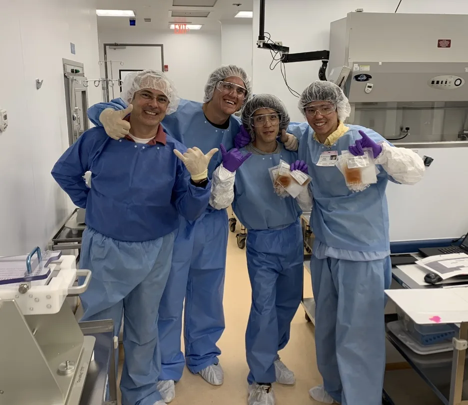 Brian Drapeau with three former colleagues in a training cleanroom